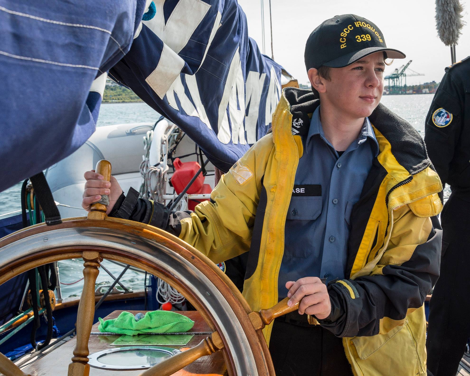 A sea cadet from Royal Canadian Sea Cadet Corps Iroquois, located in Shearwater, N.S., at the helm of HMCS Oriole, the Royal Canadian Navy’s sail training vessel.